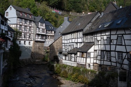 Foto de Vista de las casas y calles de la antigua ciudad alemana de colores Monschau en la curva del río y escondido entre las colinas, Parque Nacional Eifel, Alemania en verano - Imagen libre de derechos