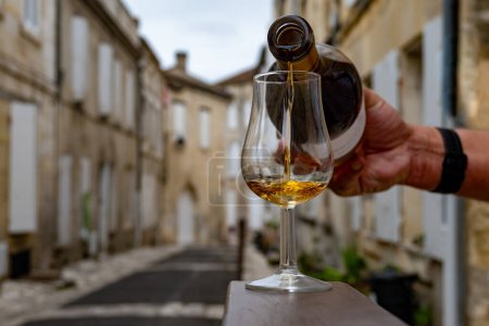 Foto de Degustación de bebidas alcohólicas envejecidas en barricas de coñac y vista de antiguas calles y casas de la ciudad Cognac, Grand Champagne, Charente, industria de destilación de licores fuertes, Francia - Imagen libre de derechos
