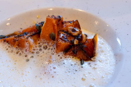 Dunkel gebratener Butterkürbis mit Schlagsahnesoße mit Ossau-Iraty-Schafskäse aus dem Baskenland, serviert in einem französischen Restaurant in der Region Bordeaux, Frankreich