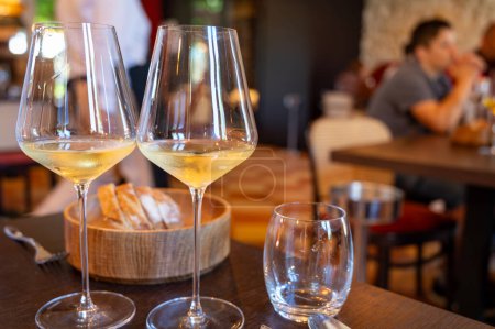Tasting of Bordeaux white wine in Sauternes, left bank of Gironde Estuary, France. Glasses of white sweet French wine served in restaurant