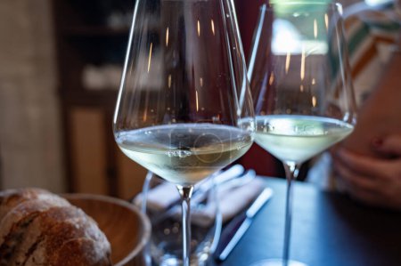 Tasting of Bordeaux white wine in Sauternes, left bank of Gironde Estuary, France. Glasses of white sweet French wine served in restaurant