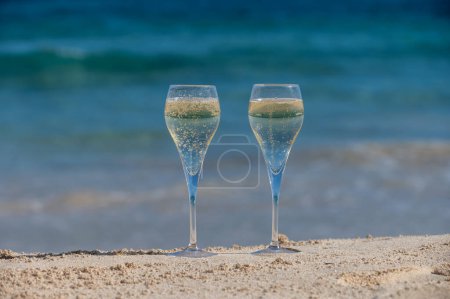 Pouring a glass of champagne on vacation, south of Fuerteventura, Canary islands, blue ocean, mountains, Spain