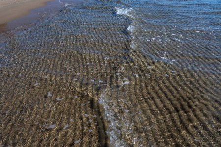 Textura de agua de mar cristalina con resplandor del sol, papel pintado, fondo de la naturaleza