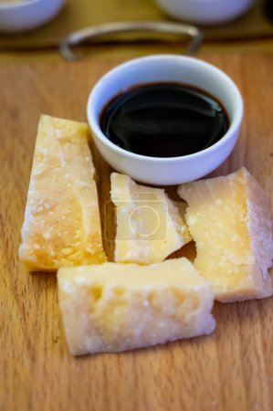 Tasting of different matured and very old parmesan Italian Parmigiano-Reggiano hard cheese and balsamic vinegar of Modena in Parma, Emilia Romagna, Italy
