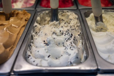 Assortment of fresh made Italian artisanal ice creams in refrigerator close up, dairy stracciatella dessert, Milan, Italy
