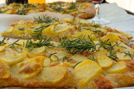 Foto de Focaccia recién horneada, pizza pala romana con verduras de patata y romero en panadería en Parma, Emilia Rumania, Italia - Imagen libre de derechos