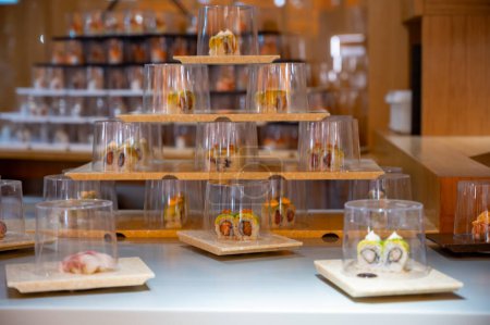 Cocina japonesa, restaurante moderno con sushi, sashimi y otros platos japoneses servidos en el cinturón móvil a través del restaurante, cafetería de almuerzo de autoservicio