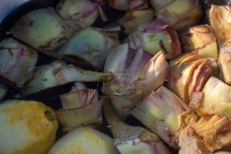 Bol avec de l'eau de citron et des c?urs de légumes romanesco violet frais de près