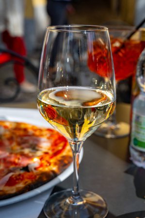 Copa de vino blanco seco frío servido al aire libre en la cafetería en Bellagio, Lago de Como, Italia, soleado día de primavera