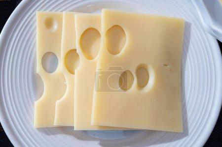 Colección de quesos suizos, emmental amarillo o emmental con agujeros redondos en rodajas de cerca