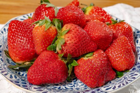 New harvest, plate with bio ripe red sweet strawberry from Spain, vegetarian food