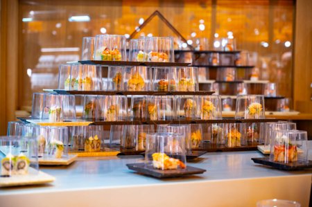 Japanese cuisine, modern restaurant with sushi, sashimi and other Japanese dishes served on moving belt across restaurant, self-service lunch cafe