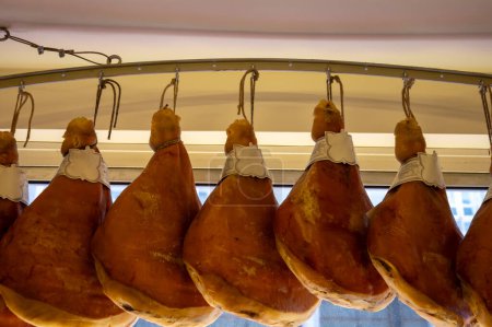Prosciutto crudo, prosciutto di Parma, uncooked, unsmoked, and dry-cured ham from Parma, Emilia-Romagna, Italy, pork legs hanging in restaurant