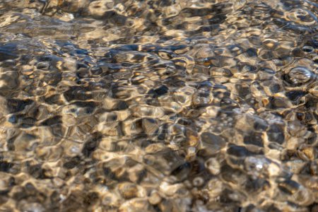Kristallklare Textur des Meerwassers mit grellem Sonnenlicht, Tapete, Naturhintergrund