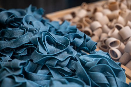 Italian food, dried handmade colorful pasta pappardelle with black spirulina, ready to cook, Milan, Lombardy, Italy