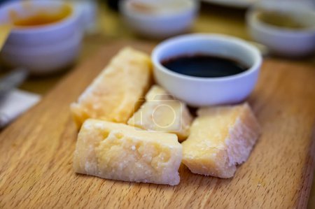Tasting of different matured and very old parmesan Italian Parmigiano-Reggiano hard cheese and balsamic vinegar of Modena in Parma, Emilia Romagna, Italy