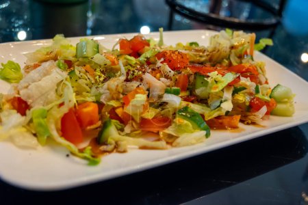 Green fresh vegetables salad for turkish mixed grill meat, chicken wings, lamb, beef shashlik, kebab in restaurant