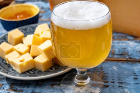 Collection de fromages, fromages à pâte dure néerlandais à base de lait de vache aux Pays-Bas en cubes et verre de bière blanche