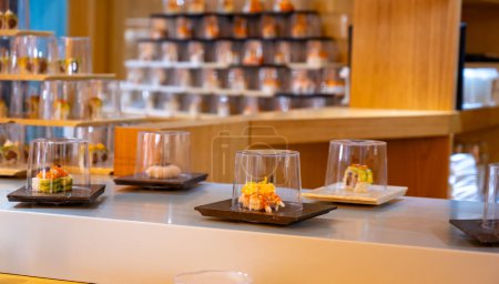 Cuisine japonaise, restaurant moderne avec sushi, sashimi et autres plats japonais servis sur ceinture mobile à travers le restaurant, café libre-service pour le déjeuner