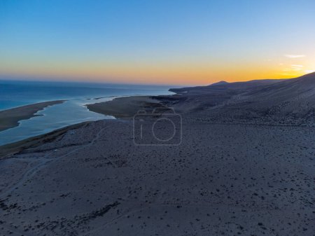 Luftaufnahme von Sanddünen und türkisfarbenem Wasser am Strand von Sotavento bei Sonnenuntergang, Costa Calma, Fuerteventura, Kanarische Inseln, Spanien im Winter