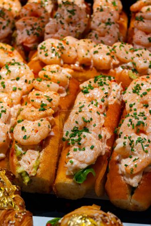 Fresh baked brioche buns filled with crab meat and shrimps ready to eat in food hall, London, Covent Garden market, UK