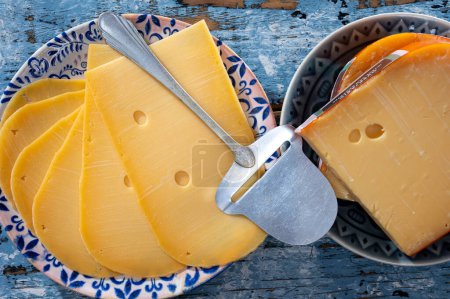 Colección de quesos, quesos duros maduros holandeses hechos de leche de vaca en los Países Bajos en trozos y rebanados de cerca