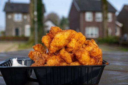 Seafood, outdoor eating of diep-fried cod fish pieces served with remoulade sauce, Dutch street food