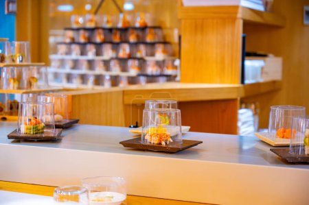 Japanische Küche, modernes Restaurant mit Sushi, Sashimi und anderen japanischen Gerichten, serviert auf einem beweglichen Band quer durch das Restaurant, Selbstbedienungs-Lunch-Café