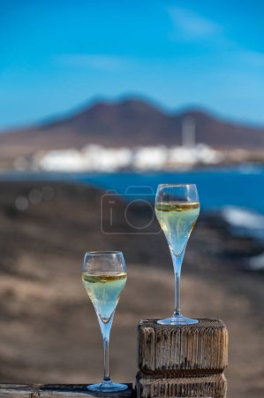 Pouring a glass of champagne on vacation, south of Fuerteventura, Canary islands, blue ocean, mountains, Spain