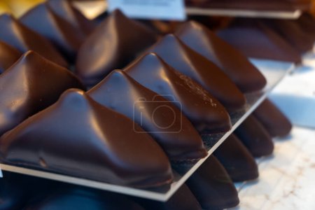 Caramelos de chocolate suizos hechos a mano de manteca de cacao de alta calidad con diferentes rellenos, fondo de chocolate