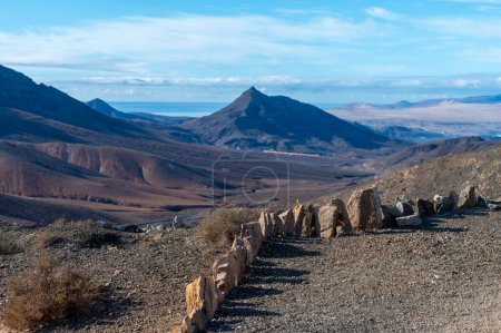 Panoramic view on colourful remote sandy isthmus of Jandia peninsula and basal hills and mountains of Massif of Betancuria, Fuerteventura, Canary islands, Spain