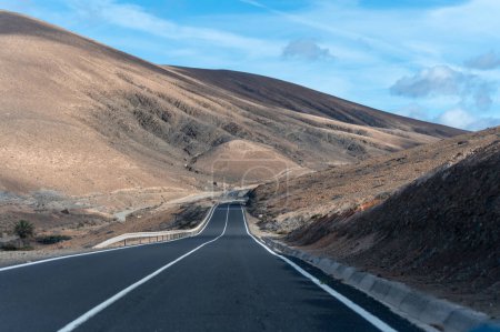 Camino de asfalto de montaña en coloridas colinas basales remotas y montañas del Macizo de Betancuria, Fuerteventura, Islas Canarias, España, destino de viaje