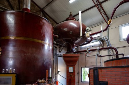 Double distillation process of cognac spirits in Charentias copper alambic still pots and boilers in old distillery in Cognac white wine region, Charente, Segonzac, Grand Champagne, France