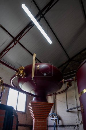 Double distillation process of cognac spirits in Charentias copper alambic still pots and boilers in old distillery in Cognac white wine region, Charente, Segonzac, Grand Champagne, France