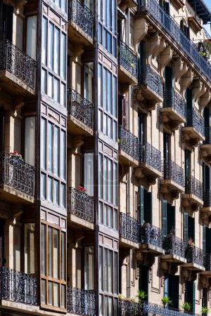 Elegant downtown, windows and balcony of famous San Sebastian or Donostia city, touristic destination in Basque Country, north of Spain