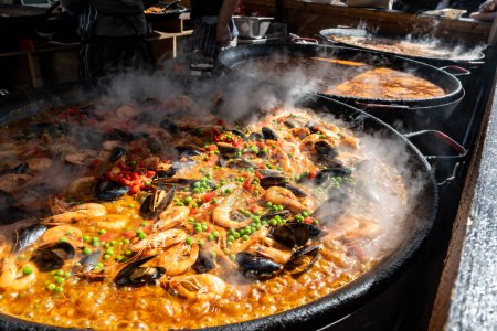 Street Food in London, Food Court an der Portobello Road samstags Markt, frisch zubereitete bunte Paella mit Reis und Meeresfrüchten in großer Pfanne, fertig zum Essen