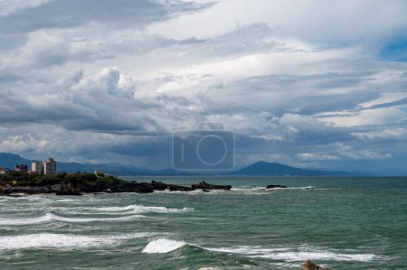 Panoramic view from lighthouse on cliffs, houses, sandy beaches of touristic Biarritz city, Basque Country, Bay of Biscay of Atlantic ocean, France, storm in Biarritz
