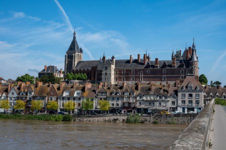 Views of old part of town of Gien on the Loire river, in Loiret department, France, houses with tiled roofs and chimneys, castle and bridge
