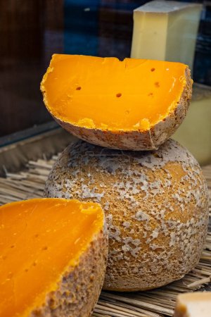 Stücke des einheimischen französischen Käses Mimolette, hergestellt in Lille mit grauem Quark, hergestellt von speziellen Käsemilben aus nächster Nähe auf dem Markt