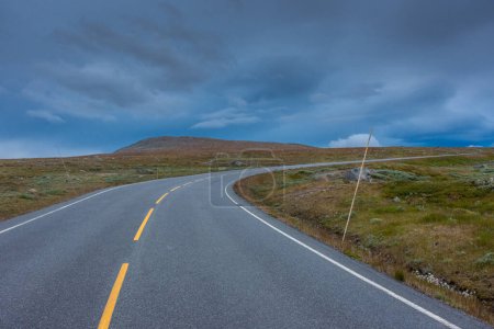 Foto de Camino vacío a través de la tundra del centro de Noruega con cielo nublado y malhumorado - Imagen libre de derechos