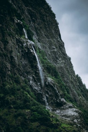 Téléchargez les photos : Paysage mouvementé avec une cascade tombant sur le Naeroyfjord à Gudvangen, Norvège - en image libre de droit