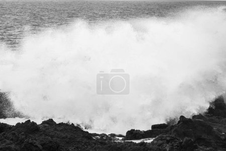 Photo for Powerful waves of the Atlantic Ocean crashing on the volcanic cliffs of Los Hervideros in Lanzarote, Canary Islands, Spain, black and white - Royalty Free Image
