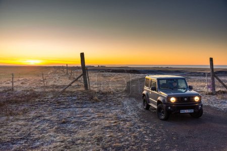 Photo for Vik, Iceland, 28 November 2022: Pick up car on the side of the wild road of Iceland at sunset - Royalty Free Image