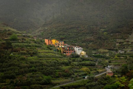 Photo for The colorful town of Volastra in the moody and foggy hills of Liguria, Cinque Terre hike, Italy - Royalty Free Image