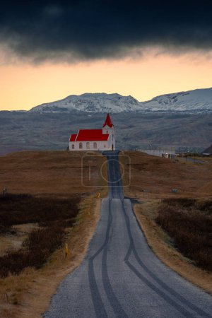 Perspektive mit der Kirche Ingjaldsholskirkja am Ende der Straße, Island