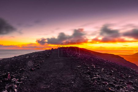 Spektakulärer Sonnenuntergang über dem Fagradalsfjall, einem aktiven Vulkan in Island, im Hintergrund das Meer