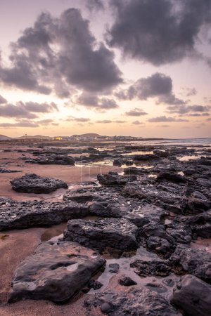 Sunset over the coastline of Famara beach on the Atlantic Ocean in Lanzarote, Canary Islands, Spain