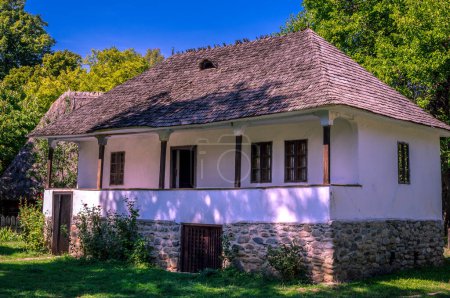 Foto de BUCHAREST, RUMANIA - Dimitrie Gusti National Village Museum, situado en el Parque Herastrau que muestra la vida tradicional de la aldea rumana. Casa del área de Arges. Foto de alta calidad - Imagen libre de derechos