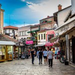 SKOPJE, NORTH MACEDONIA - 28 AUGUST 2022: Street of Old Bazaar market with pedestrians. One of the oldest markets and popular tourist shopping area in historical center of Skopje. High quality photo