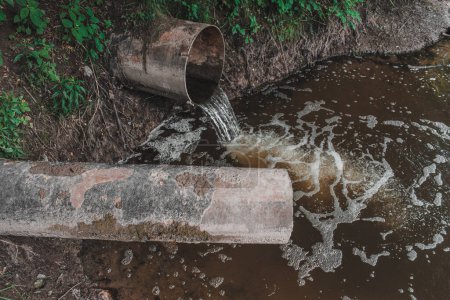 Dirty sewage from the pipe, dirty water discharged into river. Environmental pollution.